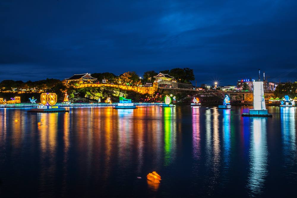 Illuminated lanterns and a fortress reflected on the Nam River at the Jinju Lantern Festival